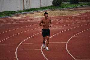 Man Running on a Track for Building Endurance, which is One of The Components of Physical Fitness